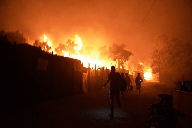 Geflchtete rennen whrend ein Feuer i...ager Moria auf der Insel Lesbos brennt  | Foto: Panagiotis Balaskas (dpa)