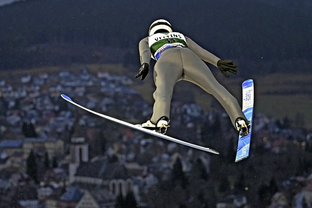 Skispringer sind nachtaktiv. Luca Roth...ne ein Menschenmeer im Zuschauerrund.   | Foto: Patrick Seeger (dpa)