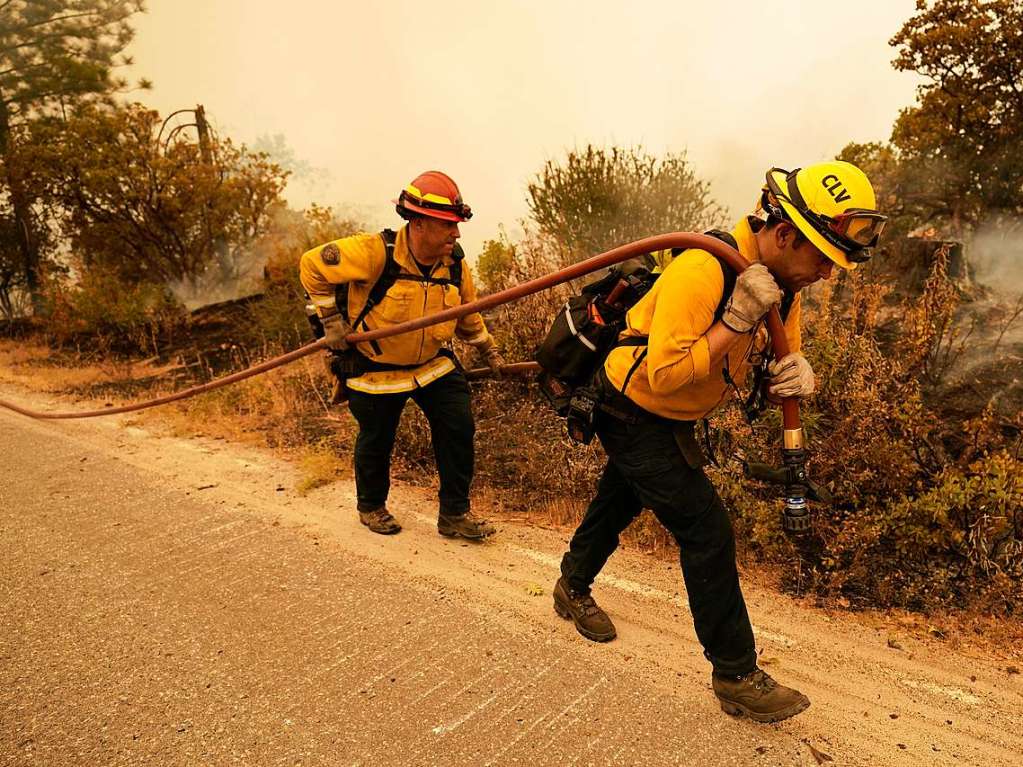 Feuerwehrleute gehen eine Strae entlang, nachdem das Creek Fire in der Gegend um Tollhouse wtete.