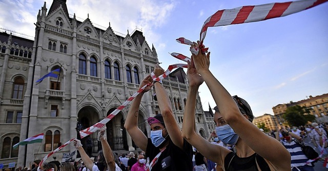 Symbol der Solidaritt: Menschenkette mit rot-weiem Band  | Foto: Marton Monus (dpa)