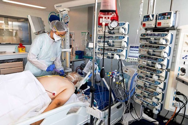 Medizinisches Personal betreut einen v...haus &quot;Nouvel Hpital Civil&quot;.  | Foto: Jean-Francois Badias (dpa)