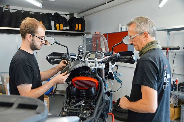 Martin Kiefer (rechts) und Julian ckert arbeiten an einem Motorrad.  | Foto: Horatio Gollin