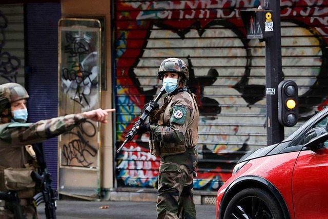 Polizisten patrouillieren an einer Str...sind mehrere Menschen verletzt worden.  | Foto: Thibault Camus (dpa)