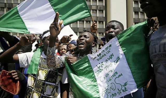 Demonstranten in Lagos schwenken die nigerianische Flagge.  | Foto: Sunday Alamba (dpa)