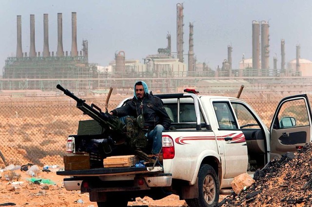 Seine Flugabwehrwaffe soll er jetzt ni...ell vor einer lraffinerie in Libyen.   | Foto: Hussein Malla (dpa)