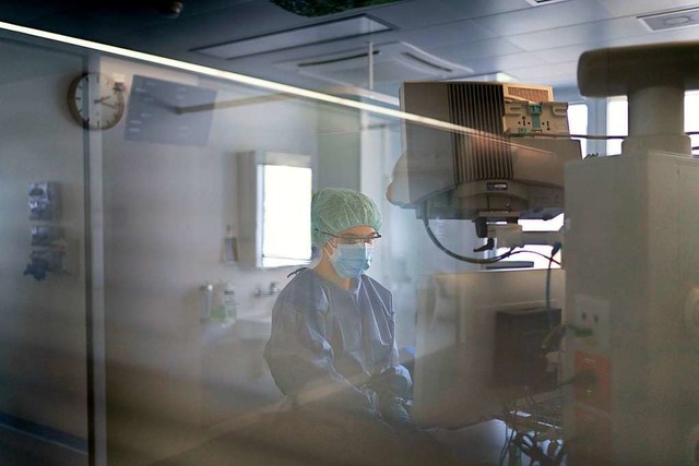 Pflegepersonal behandelt einen Covid-1...station eines Krankenhauses in Schwyz.  | Foto: Gaetan Bally (dpa)
