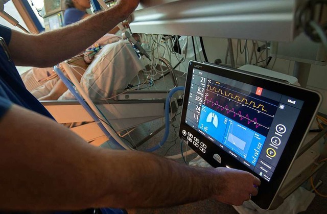 Ein Arzt bedient eine Beatmungsmaschine auf einer Intensivstation (Symbolbild).  | Foto: Marijan Murat (dpa)