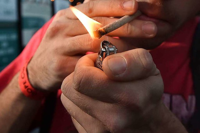 Ein Mann zndet sich einen Joint an.  | Foto: JOSH EDELSON (AFP)