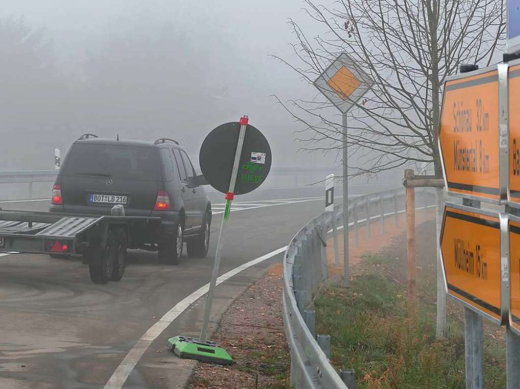 … und die ersten Autos fahren auf die neue Strae, am einen wie am anderen Ende jeweils ein schwarzer Mercedes