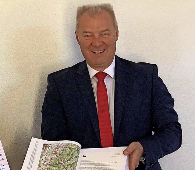 Klaus Bhler von der Sparkasse mit dem Ortssippenbuch  | Foto: Gemeinde