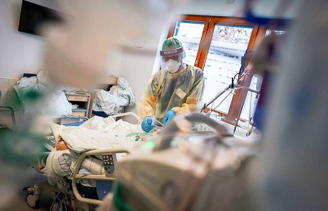 Ein Intensivpfleger behandelt einen Co...ation des Krankenhauses Bethel Berlin.  | Foto: Kay Nietfeld (dpa)