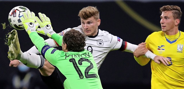 Doppeltorschtze Timo Werner hebt hier...echts dessen Mitspieler Illia Sabarnyi  | Foto: RONNY HARTMANN (AFP)