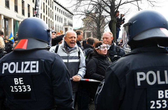 Teilnehmer einer Demonstration gegen d...r und dem Reichstagsgebude gegenber.  | Foto: Paul Zinken (dpa)