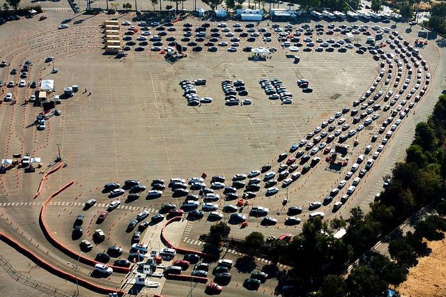 Autofahrer warten in ihren Fahrzeugen ..., um dort einen Corona-Test zu machen.  | Foto: Ringo H.W. Chiu (dpa)