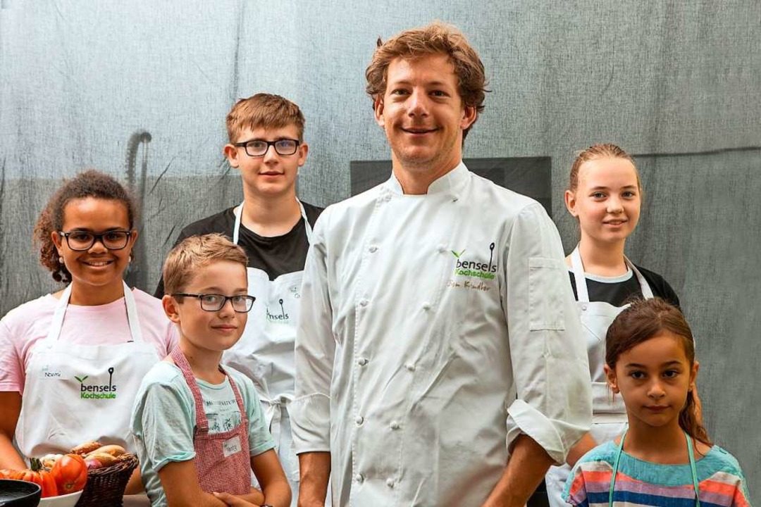 Ben Kindler bei einem Kinderkurs, umringt von jungen Köchinnen und Köchen  | Foto: Joss Andres