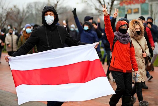 Ein Demonstrant hlt bei einem Protest...gen Lukaschenko friedlich protestiert.  | Foto: - (dpa)