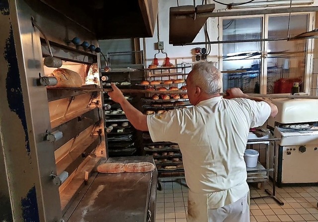 Helmuth Bender holt das fertige Brot aus dem Ofen.   | Foto: Anja Hoffmann