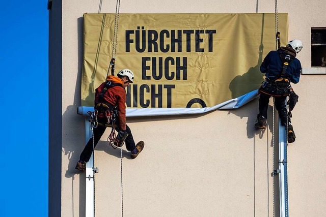 Fassadenkletterer bringen  ein Adventsbanner am Turm der Hugstetter Kirche an.  | Foto: Hubert Gemmert