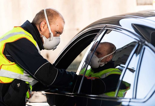 Ein Bundespolizist berprft Autofahre...e nicht gegen Corona-Regeln verstoen.  | Foto: Patrick Seeger (dpa)