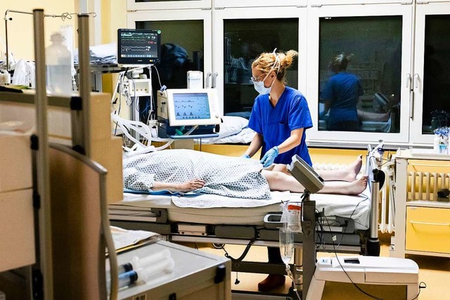 Melina Ltje, Krankenschwester auf der...lstein, steht am Bett einer Patientin.  | Foto: Frank Molter (dpa)