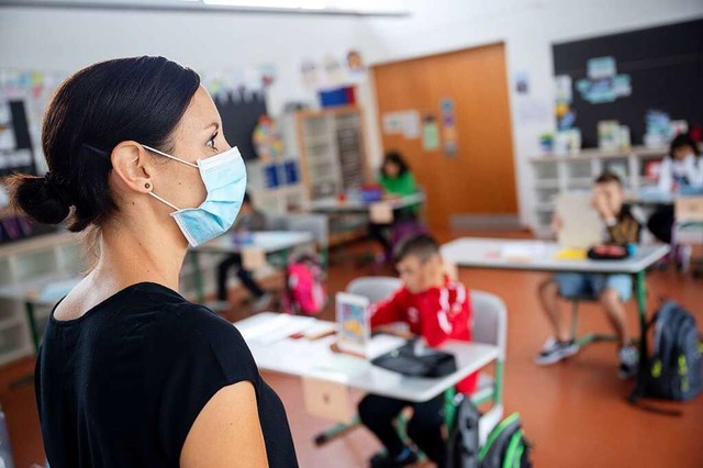Eine Lehrerin mit Maske steht vor einer Grundschulklasse (Symbolbild).  | Foto: Sebastian Gollnow (dpa)