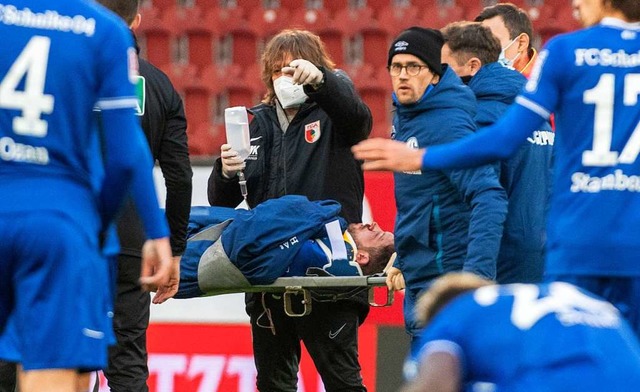 Augsburgs Mannschaftsarzt Andreas Weig... gibt Schalkes Mark Uth eine Infusion.  | Foto: Stefan Puchner (dpa)