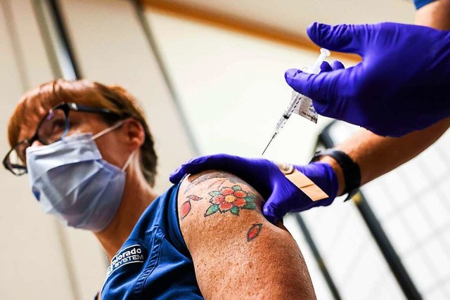 Eine Krankenschwester im US-Bundesstaa...h die Impfung von Biontech und Pfizer.  | Foto: Michael Ciaglo (AFP)