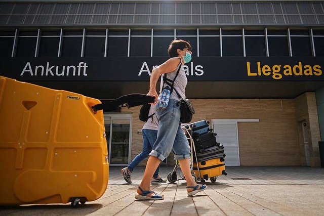 Eine Touristin zieht einen Rollkoffer ...kunft auf dem Flughafen Teneriffa Sd.  | Foto: Andrs Gutirrez (dpa)