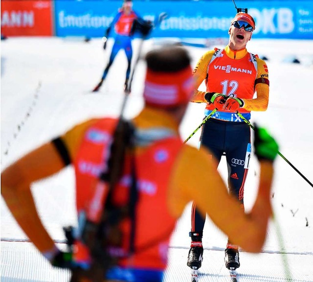 Arnd Peiffer schaut zu, wie Teamkolleg...oll (rechts) die Ziellinie berquert.   | Foto: BARBARA GINDL (AFP)