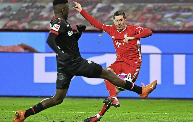 Robert Lewandowski (rechts) trifft in ...iger Tapsoba den Ball noch abflscht.   | Foto: Bernd Thissen (dpa)