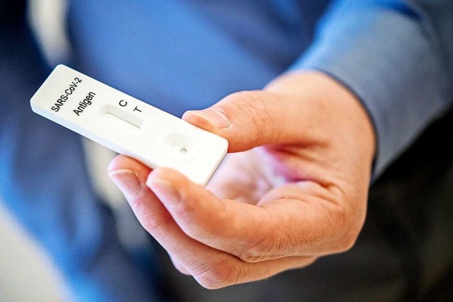 Ein Mann hlt einen Schnelltest zur Erkennung des Coronavirus in der Hand.  | Foto: Hauke-Christian Dittrich (dpa)