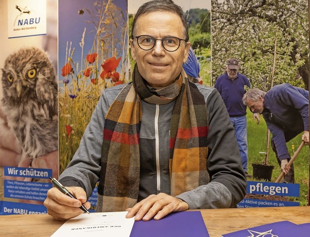 Jrgen Glocker signiert seine neue Wei...um am Naturena Badesee in Birkendorf.   | Foto: Wilfried Dieckmann