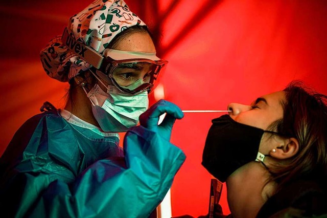 Bei einer jungen Frau wird ein Nasenabstrich genommen.  | Foto: Matthias Oesterle (dpa)