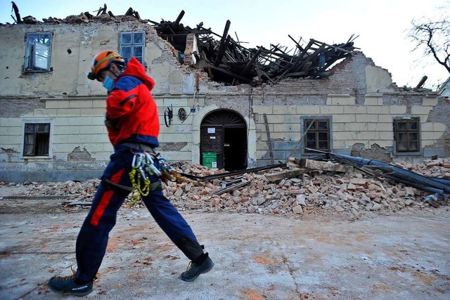 in Mitglied der Rettungskrfte geht vo... Erdbeben eingestrzten Hauses vorbei.  | Foto: Uncredited (dpa)