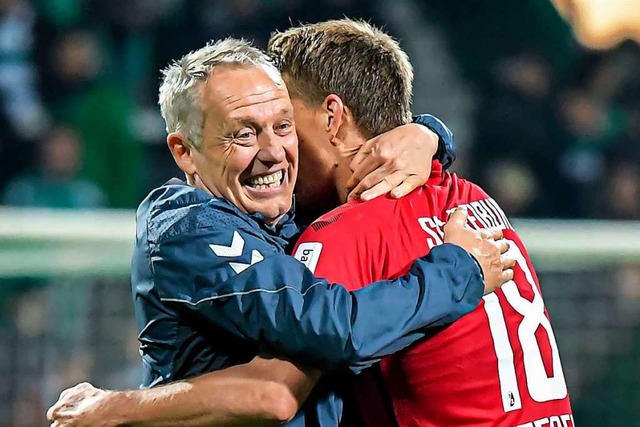 Zugewandtheit: Christian Streich freut sich mit Nils Petersen.  | Foto: Axel Heimken (dpa)