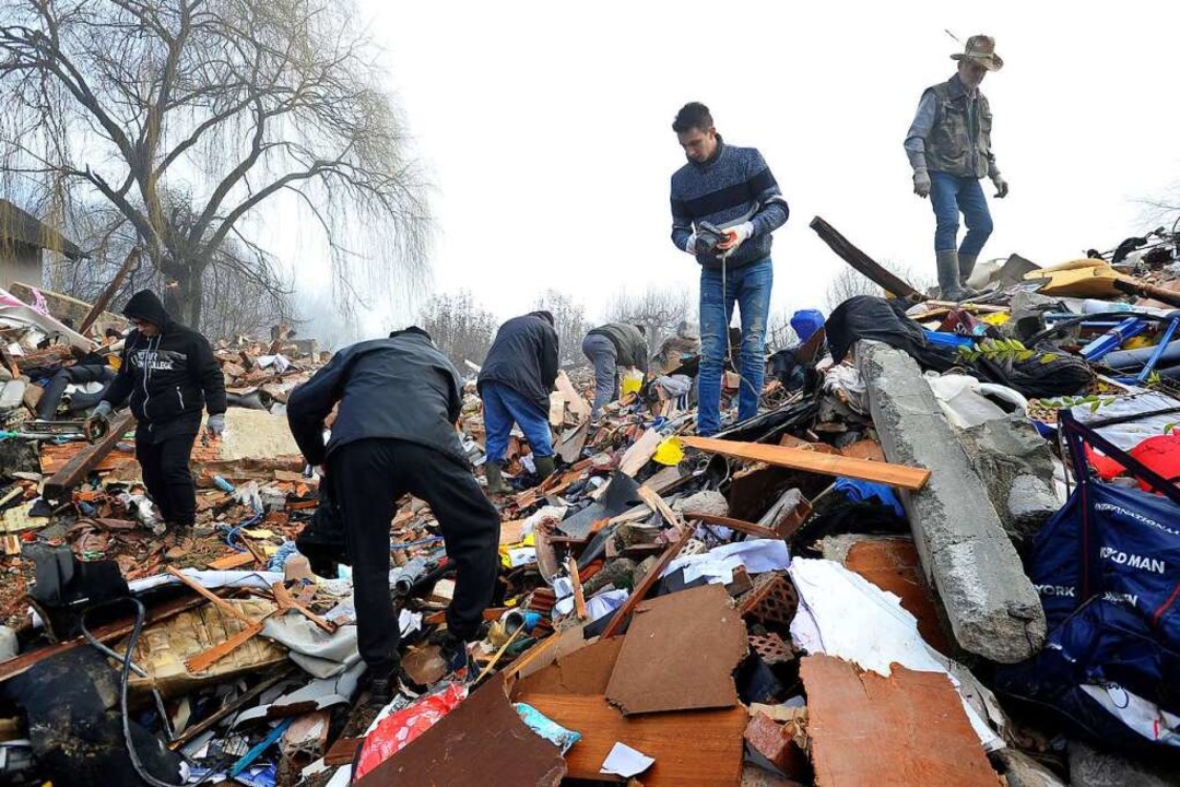 Menschen durchsuchen Trümmer in Poljana.  | Foto: -- (dpa)