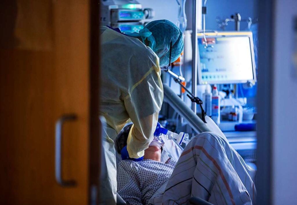 Eine Intensivfachkraft versorgt eine Patientin mit Corona-Infektion.  | Foto: Jens Büttner