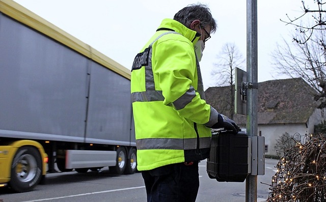 Ein Mitarbeiter des Landkreises Lrrac...220; eine Tempomessanlage installiert.  | Foto: Victoria Langelott