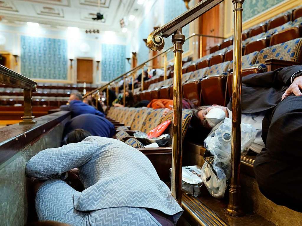 Menschen suchen Schutz auf der Tribne des Reprsentantenhauses, whrend Demonstranten versuchen, in die Reprsentantenkammer im US-Kapitol einzudringen.