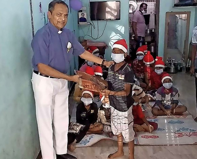 Father Joe Pereira mit Straenkindern in Indien bei einer Weihnachtsfeier   | Foto: KRIPA