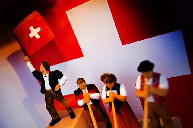 Klischees in Holz geschnitzt: Figuren mit Schweizerflagge und Alphorn  | Foto: Arno Burgi