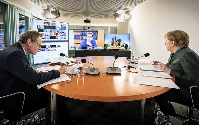 Kanzlerin Angela Merkel (r.) und Berli...ichael Mller whrend der Videoschalte  | Foto: Steffen Kugler (dpa)