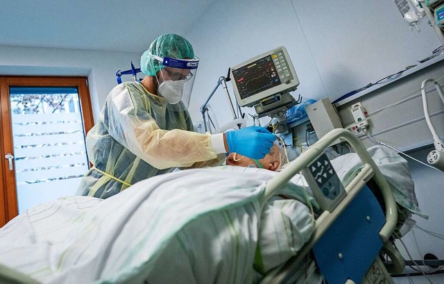 Ein Pfleger betreut einen Covid-19-Patienten auf einer Intensivstation.  | Foto: Kay Nietfeld (dpa)