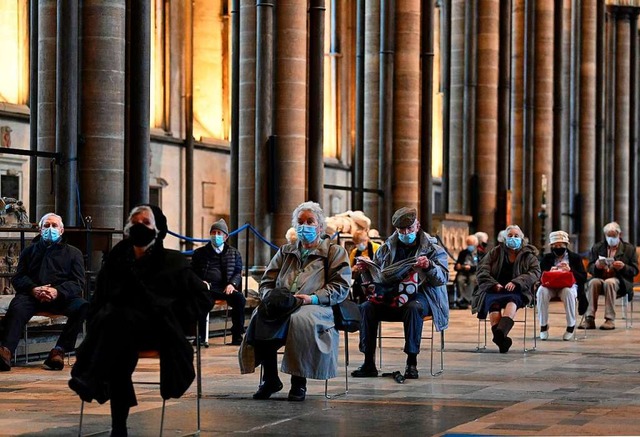 Menschen warten in der Kathedrale von Salisbury auf ihre Impfung.  | Foto: JUSTIN TALLIS (AFP)