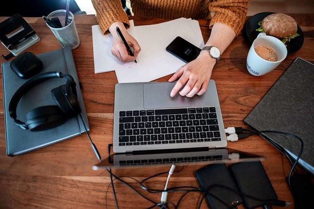 Eine Frau sitzt mit einem Laptop an einem Tisch im Homeoffice.  | Foto: Fabian Strauch (dpa)