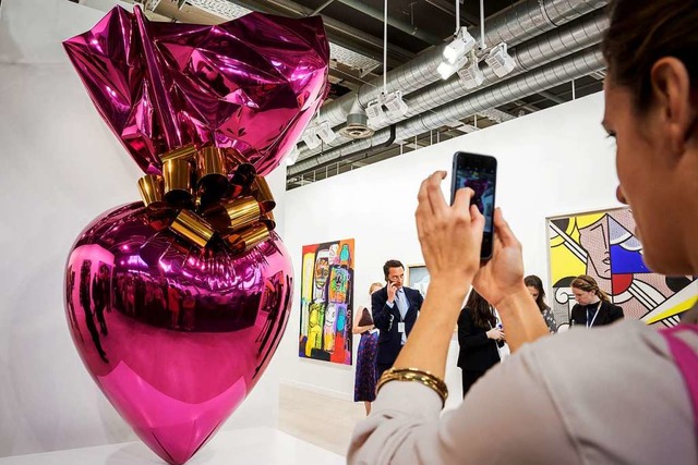 Eine Besucherin fotografiert bei der Art Basel 2019 eine Arbeit von Jeff Koons.  | Foto: FABRICE COFFRINI (AFP)