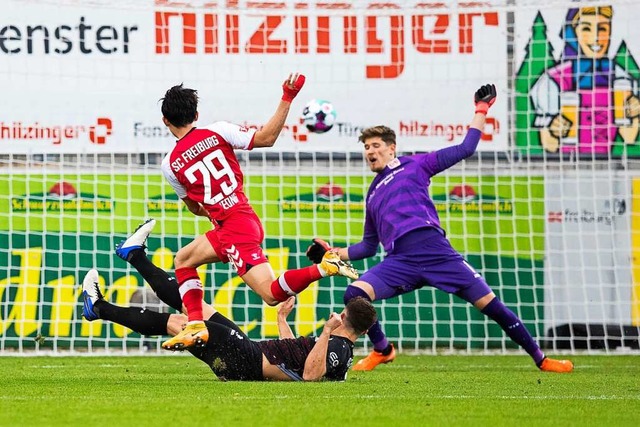 Freiburgs Woo-yeong Jeong (vorne) mach...gegen Stuttgarts Torwart Gregor Kobel.  | Foto: Tom Weller (dpa)