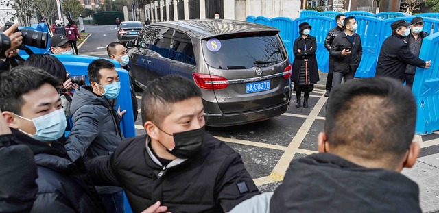 Die Delegation der WHO wird von Sicherheitskrften abgeschirmt.  | Foto: HECTOR RETAMAL (AFP)