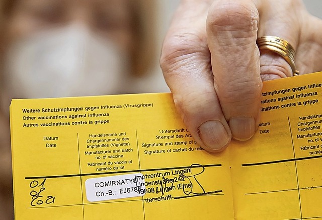 Sie war schon dran: Eine Seniorin hlt...ung gegen das Coronavirus in der Hand.  | Foto: Friso Gentsch (dpa)