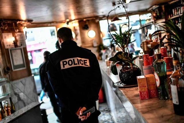 Polizeibeamte kontrollieren eine Bar i...der Corona-Einschrnkungen des Landes.  | Foto: STEPHANE DE SAKUTIN (AFP)
